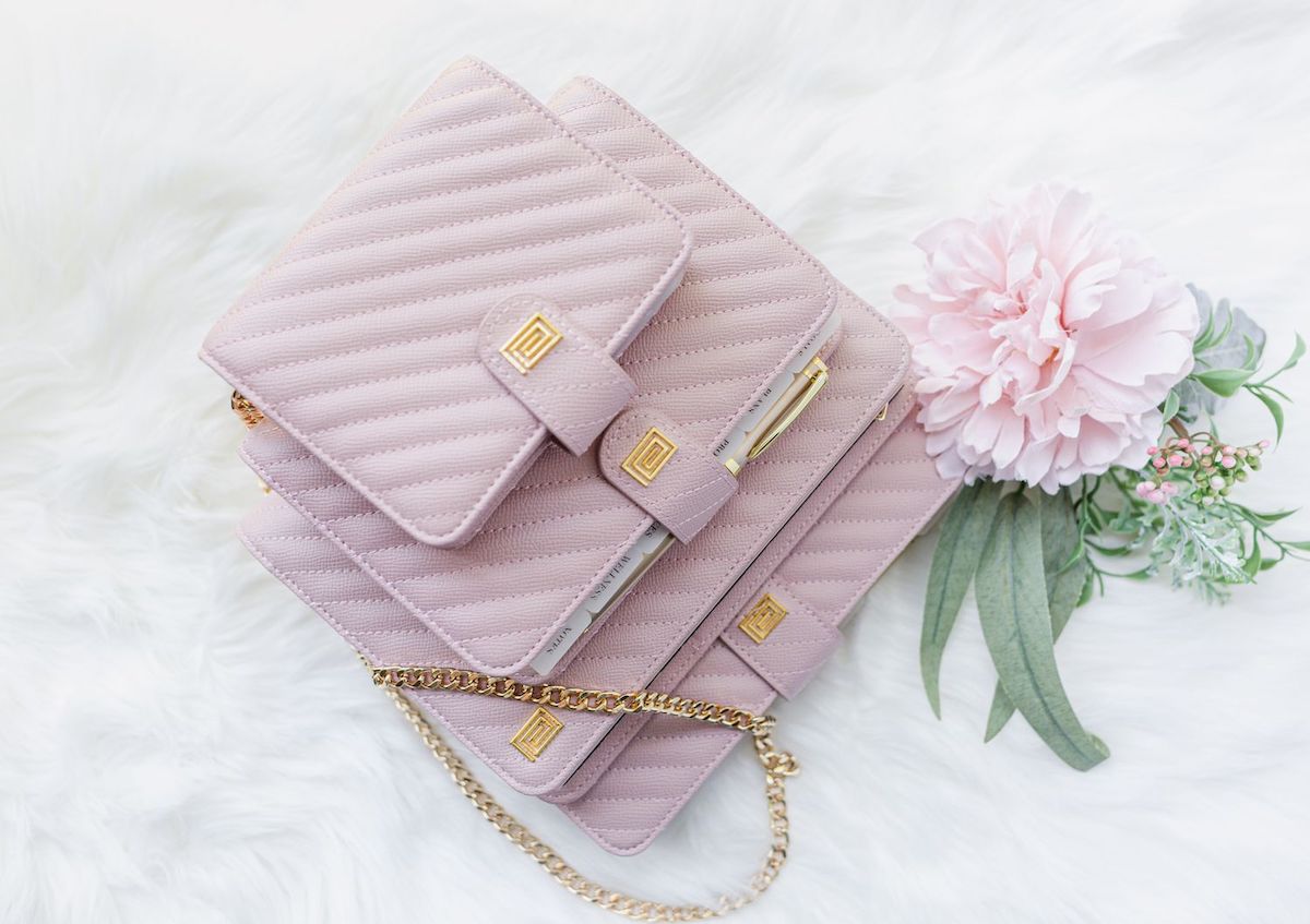 Luxury vegan leather blush pink quilted planner stack beside flower.