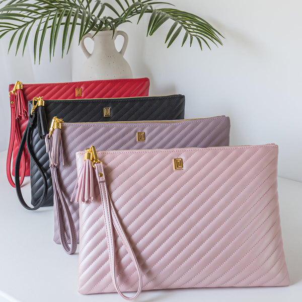 A collection of quilted vegan leather pouches in red, black, mauve, and blush.