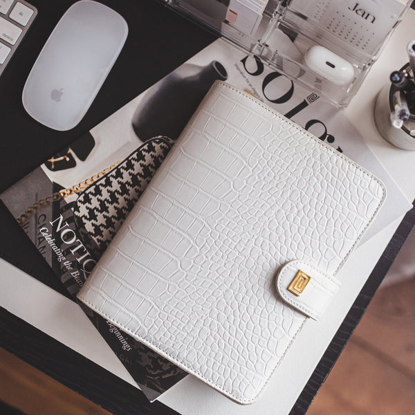 Luxury vegan leather white croco agenda cover and fashion magazine on office desk.