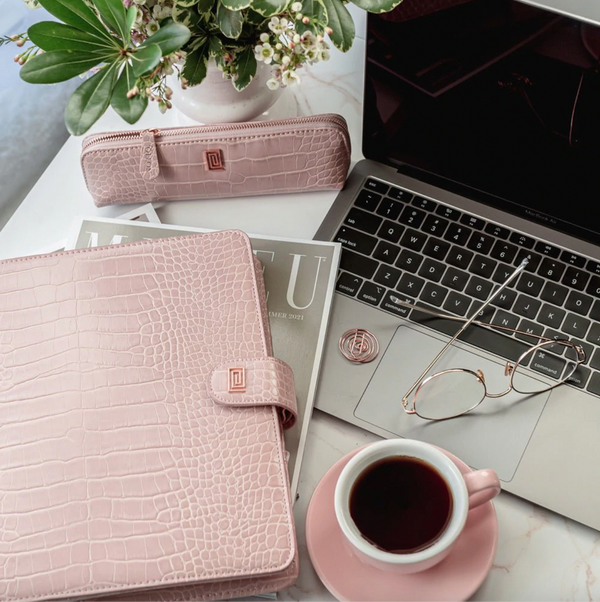 Luxury vegan leather pink croco agenda with laptop, pencil case, and coffee.